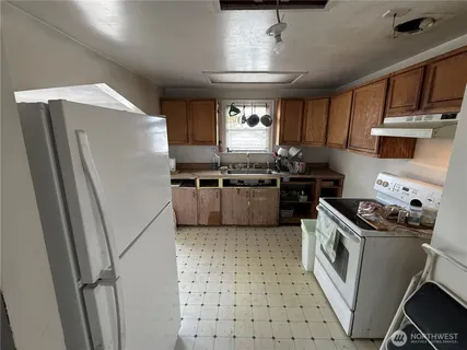 a kitchen with stainless steel appliances granite countertop a stove a sink dishwasher a refrigerator and cabinets with wooden floor