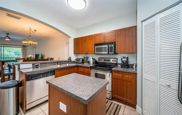 a kitchen with stainless steel appliances granite countertop a stove top oven a sink dishwasher a microwave oven with granite countertops and cabinets
