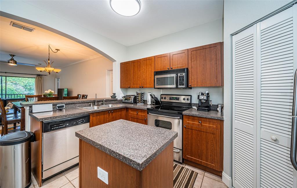 2138 Chianti Place, Unit 142 Palm Harbor, FL 34683 - Photo 11 of 40 a kitchen with stainless steel appliances granite countertop a stove top oven a sink dishwasher a microwave oven with granite countertops and cabinets