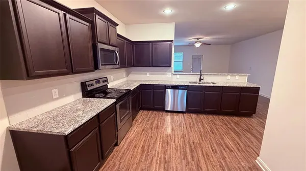 a kitchen with stainless steel appliances granite countertop wooden cabinets a sink and dishwasher