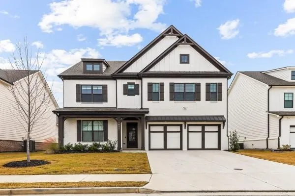 a front view of a house with white walls and a floor to ceiling window