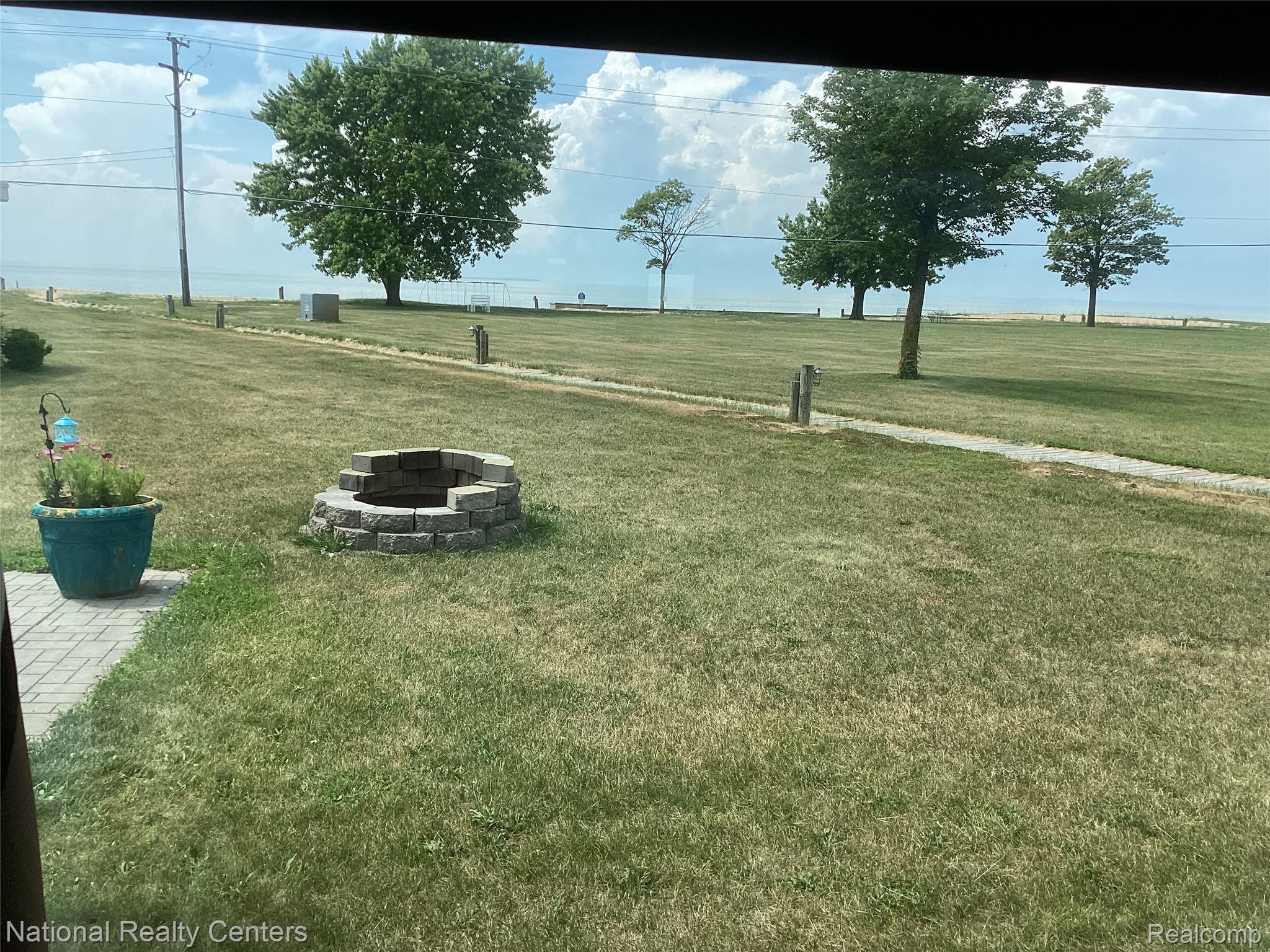 6024 Port Austin Road, Unit 5 Caseville, MI 48725 - Photo 4 of 56 Looking at grass area, beach, lake from custom patio