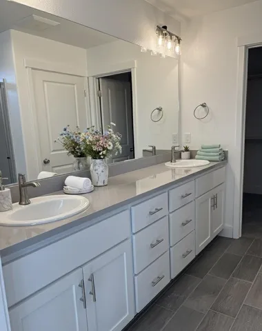a bathroom with double sink and a mirror
