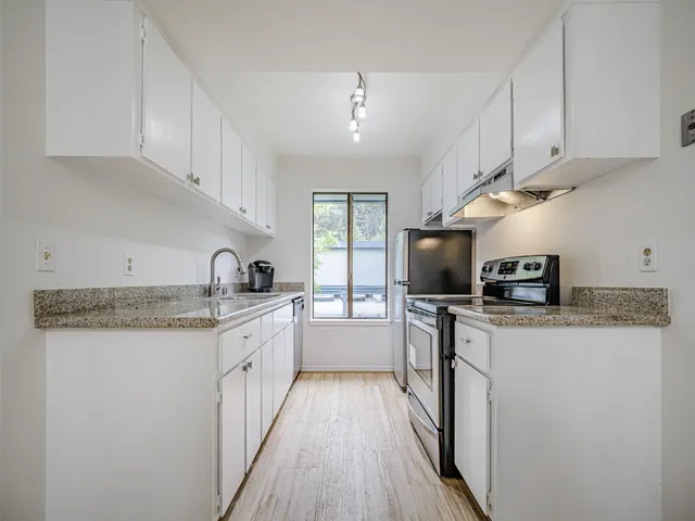 a kitchen with a sink cabinets and window
