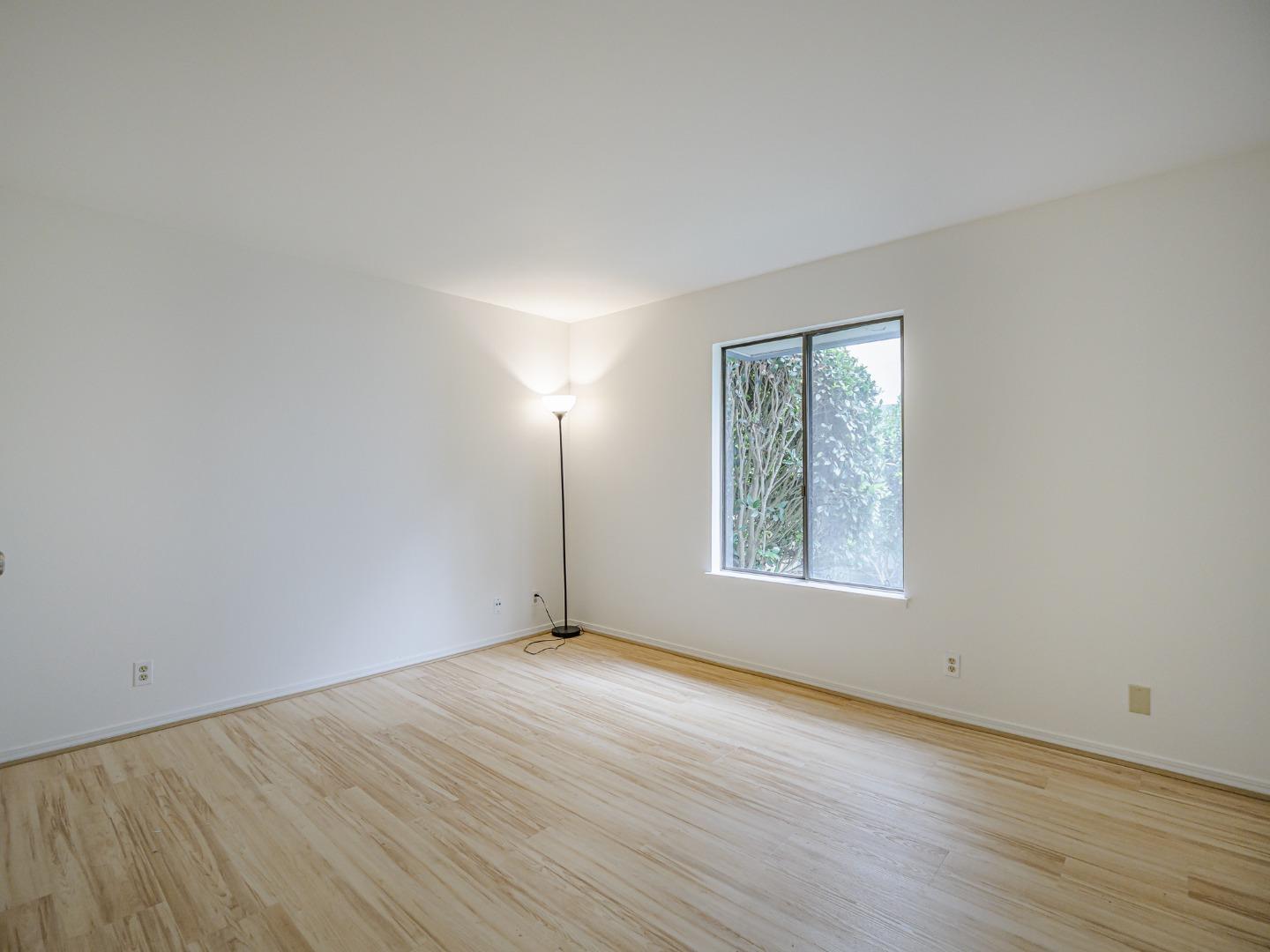 1925 46th Avenue, Unit 71 Capitola, CA 95010 - Photo 15 of 36 an empty room with wooden floor and windows