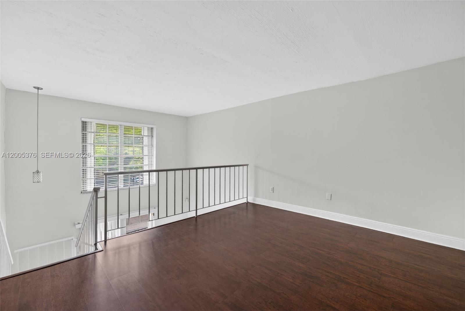 8550 Southwest 109th Avenue, Unit 5217 Miami, FL 33173 - Photo 17 of 34 a view of an empty room with wooden floor and a window