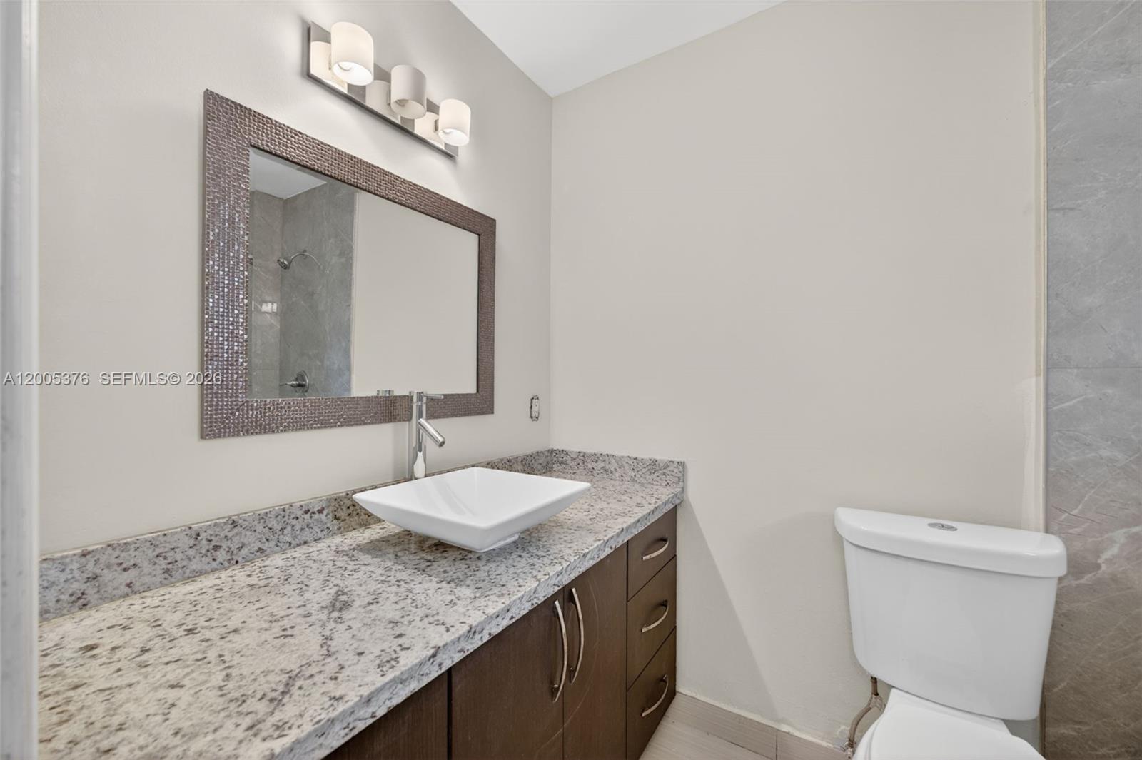 8550 Southwest 109th Avenue, Unit 5217 Miami, FL 33173 - Photo 22 of 34 a bathroom with a granite countertop sink and a mirror