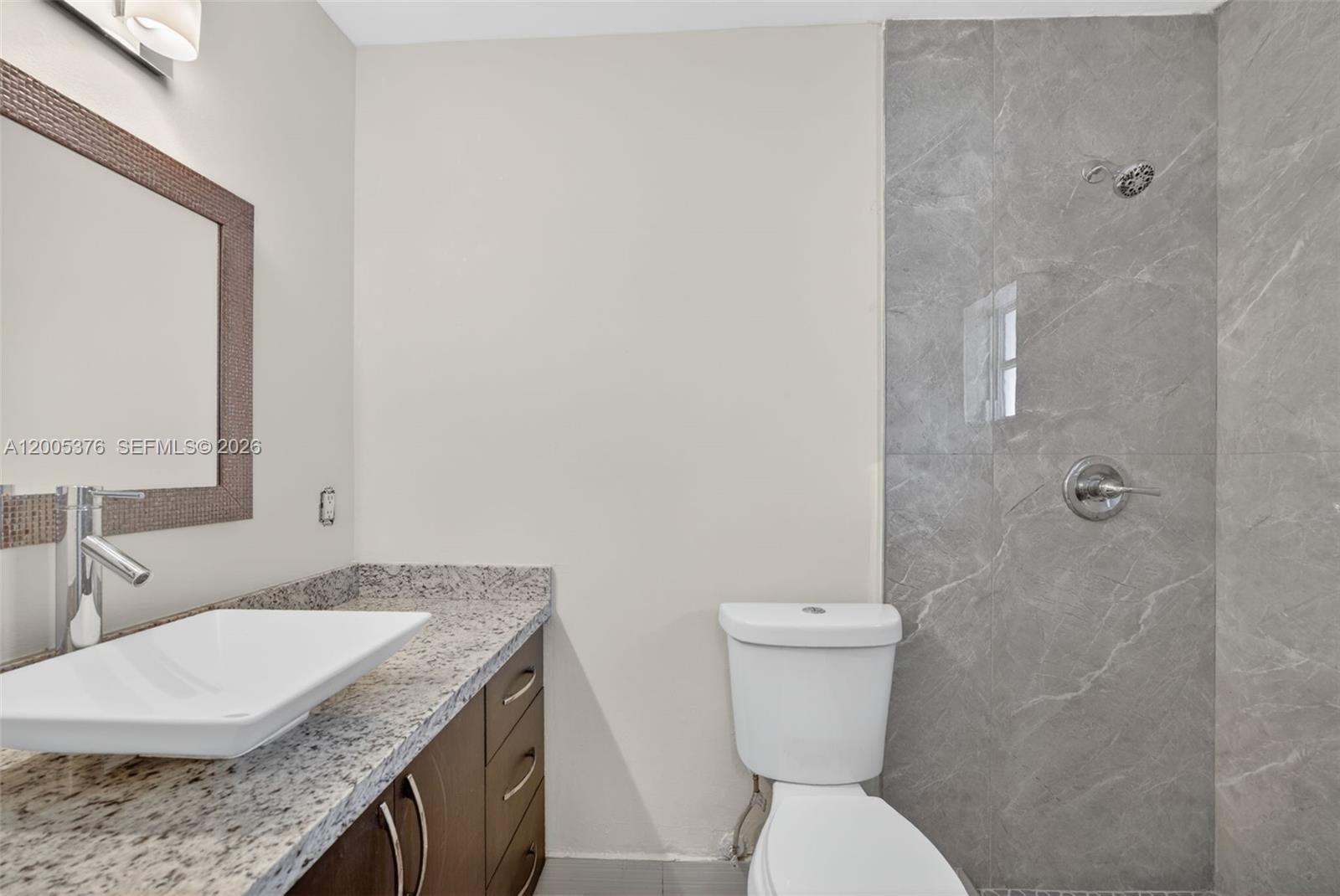 8550 Southwest 109th Avenue, Unit 5217 Miami, FL 33173 - Photo 23 of 34 a bathroom with a granite countertop toilet sink and mirror