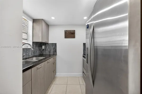 a kitchen with stainless steel appliances granite countertop a refrigerator and a sink