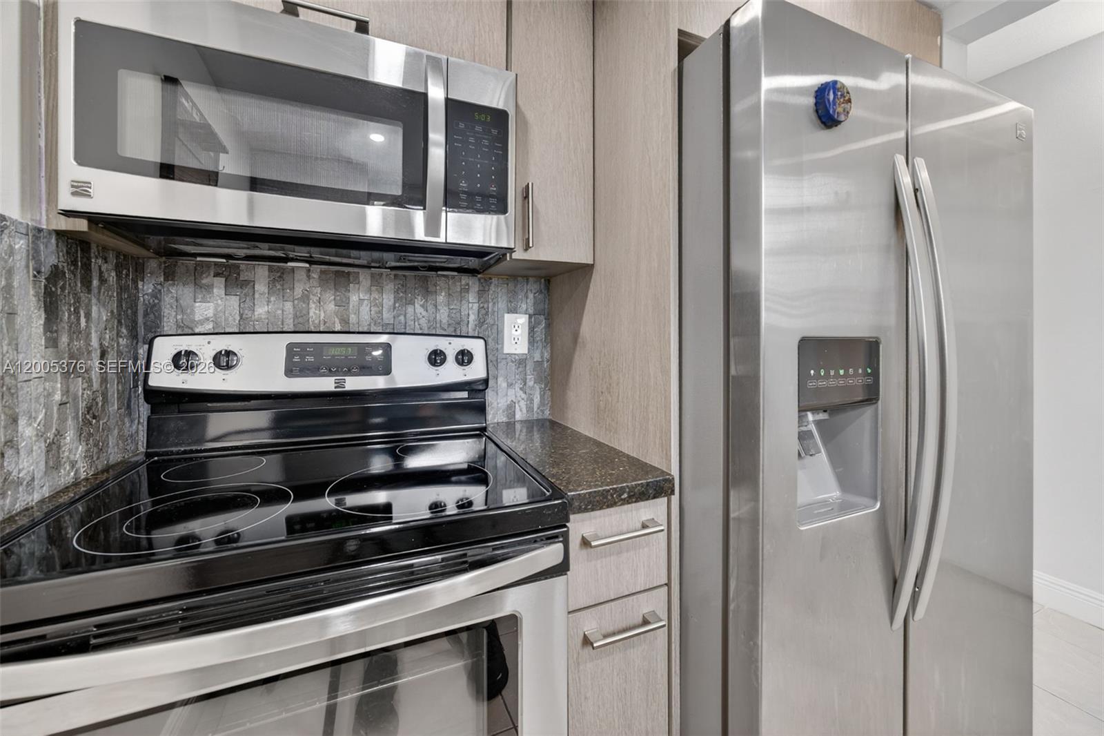 8550 Southwest 109th Avenue, Unit 5217 Miami, FL 33173 - Photo 6 of 34 a kitchen with stainless steel appliances granite countertop a stove and a microwave