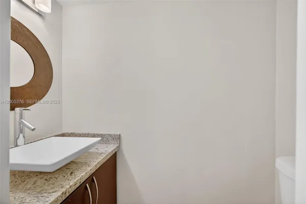 a bathroom with a granite countertop sink and a mirror