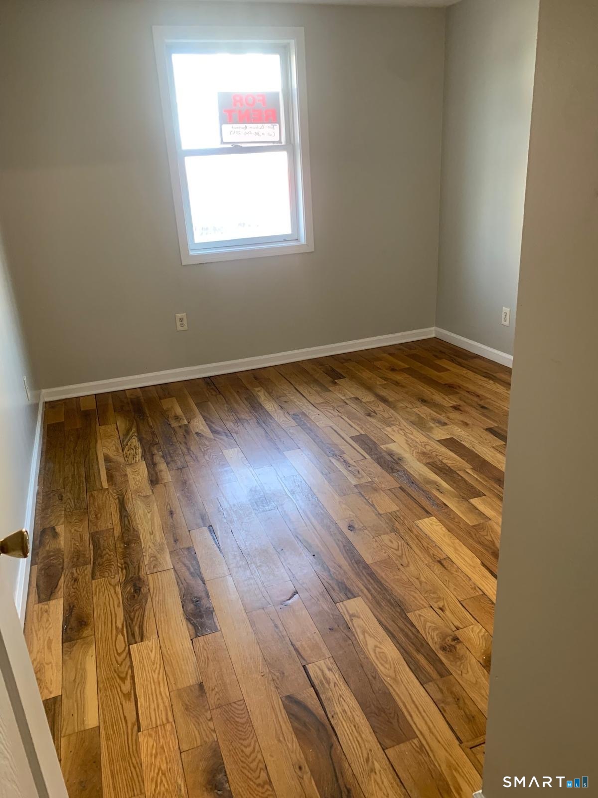 1410 Stratford Avenue Bridgeport, CT 06607 - Photo 4 of 6 a view of an empty room with wooden floor and a window