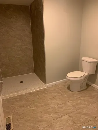 a bathroom with a toilet and a shower