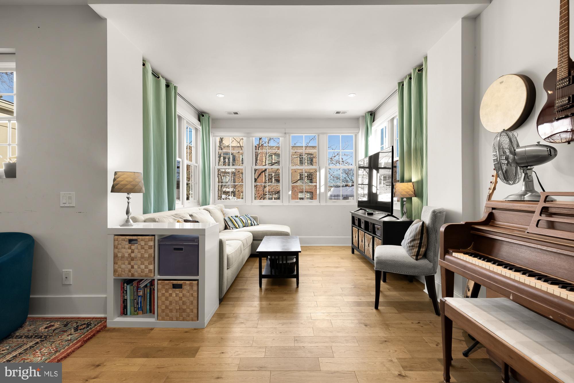 a living room with furniture a fireplace and large windows