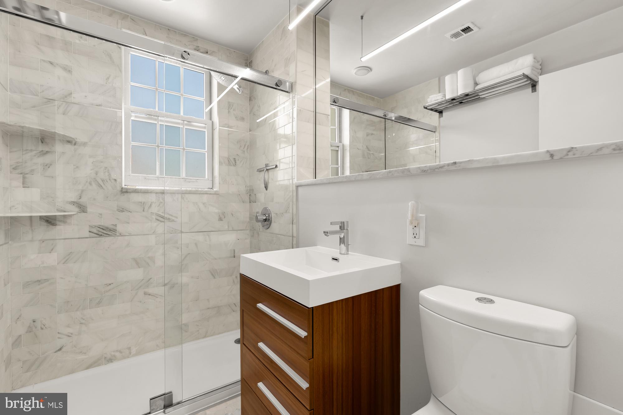 2926 Porter Street Northwest, Unit 306 Washington, DC 20008 - Photo 10 of 19 a bathroom with a sink toilet vanity and shower