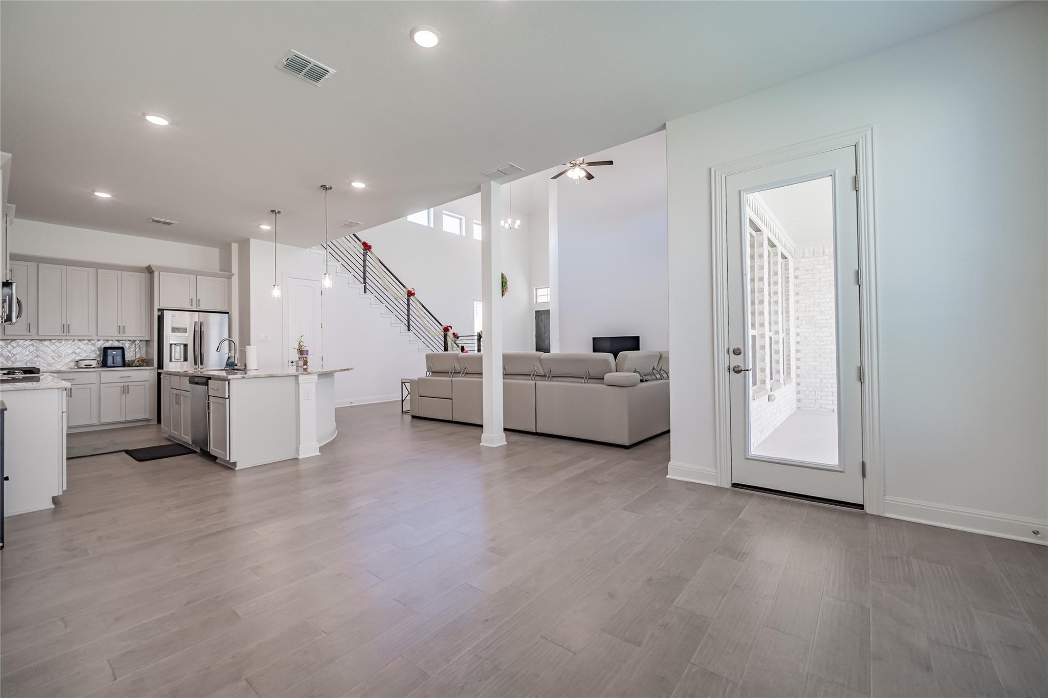 3049 Sage Ranch Drive Leander, TX 78641 - Photo 5 of 23 An airy great room seamlessly blends a modern kitchen with a comfortable living space, featuring high ceilings.
