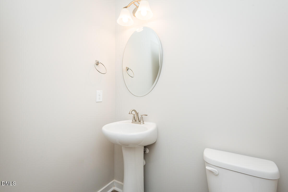 2823 Ricolden Trail Elon, NC 27244 - Photo 14 of 26 a bathroom with a sink a toilet and mirror