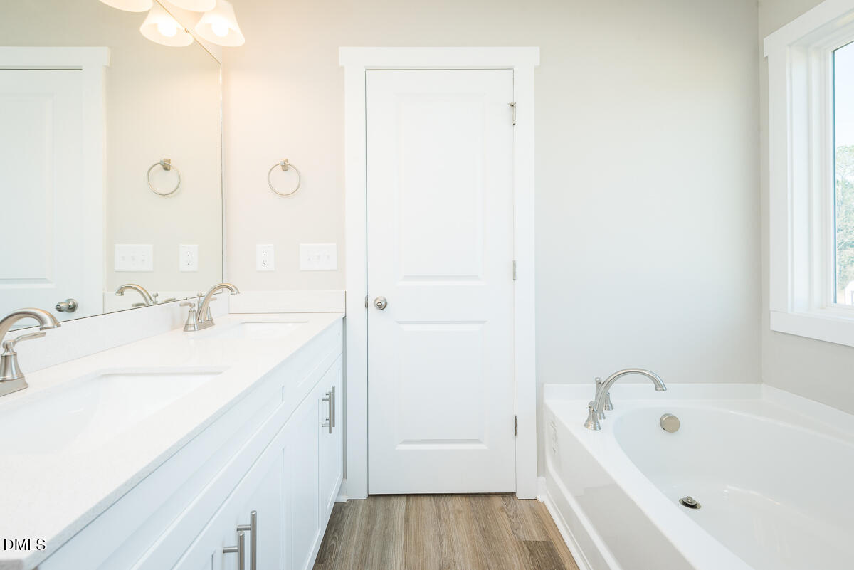 2823 Ricolden Trail Elon, NC 27244 - Photo 24 of 26 a bathroom with a tub sink and mirror