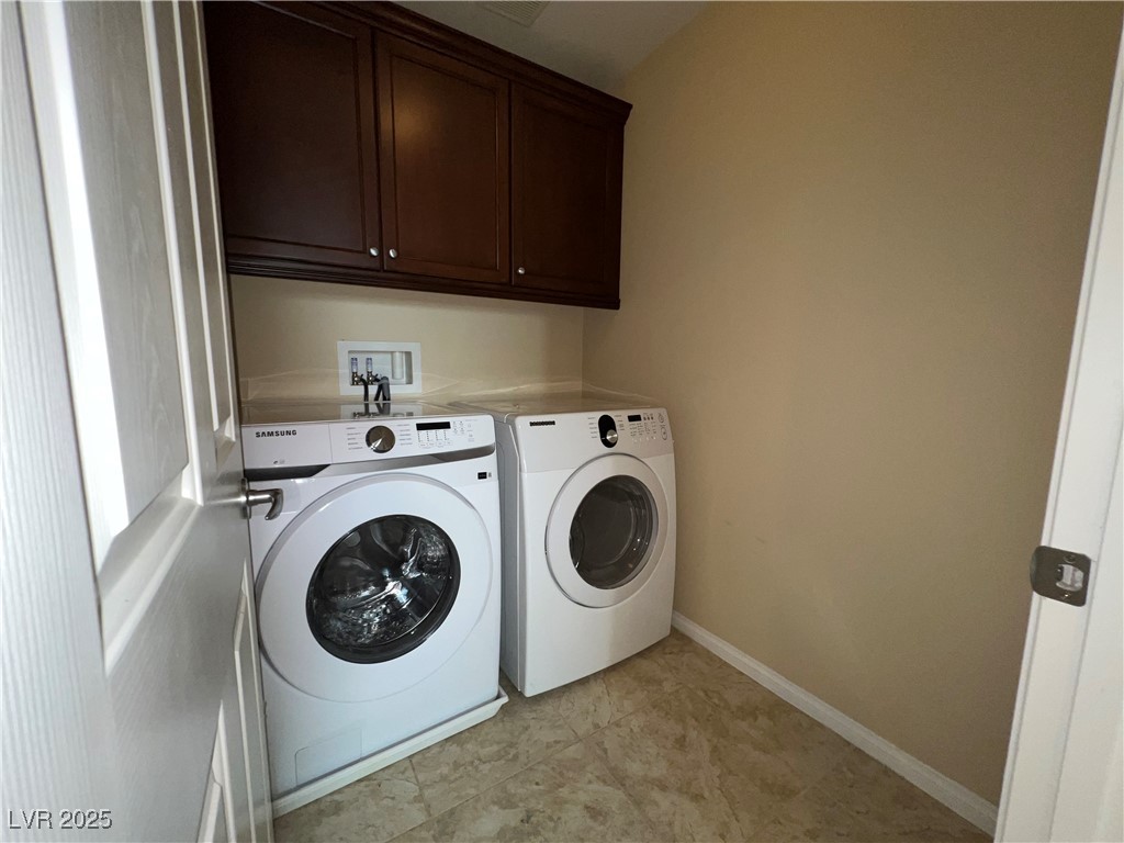 6592 Benvolio Court Las Vegas, NV 89141 - Photo 2 of 27 Laundry room featuring washing machine and dryer, cabinet space, and light tile patterned flooring