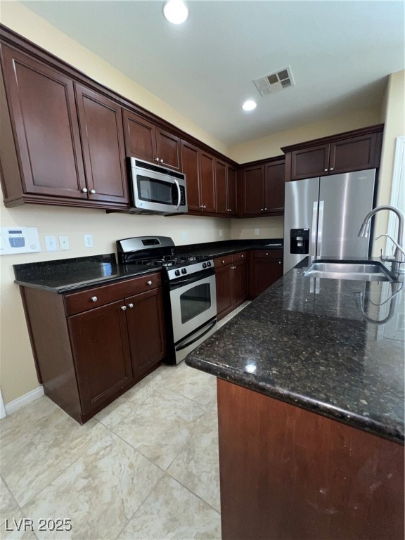 6592 Benvolio Court Las Vegas, NV 89141 - Photo 23 of 27 Kitchen with appliances with stainless steel finishes, dark stone counters, recessed lighting, and dark brown cabinetry
