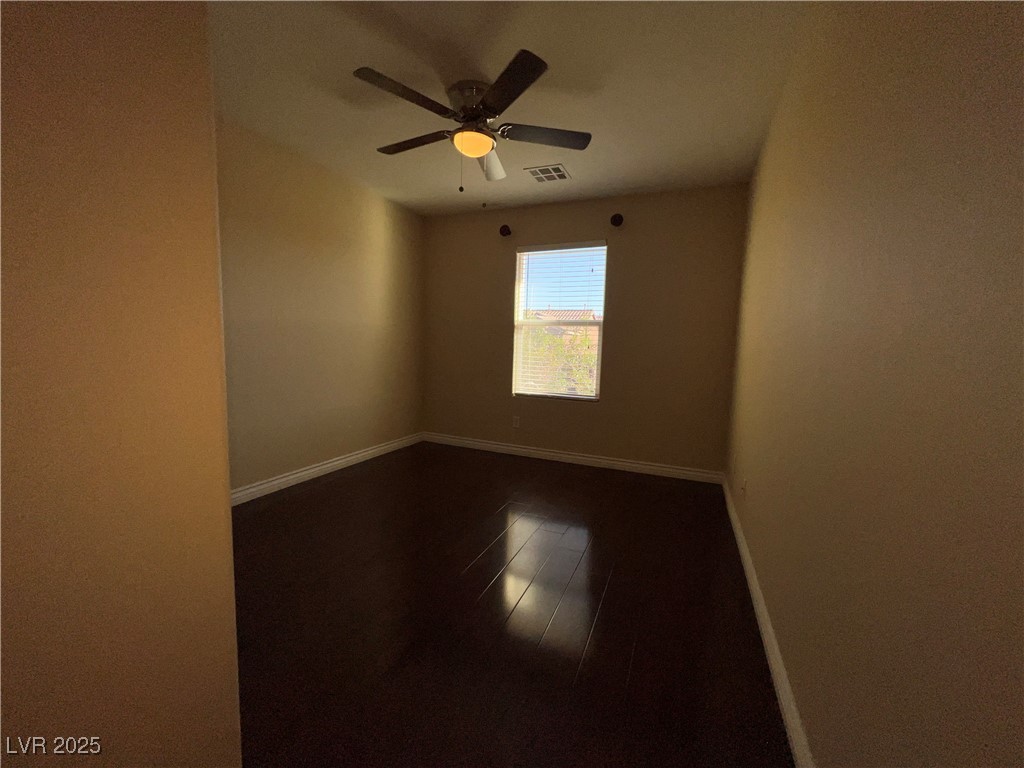 6592 Benvolio Court Las Vegas, NV 89141 - Photo 4 of 27 Unfurnished room featuring dark wood finished floors and a ceiling fan