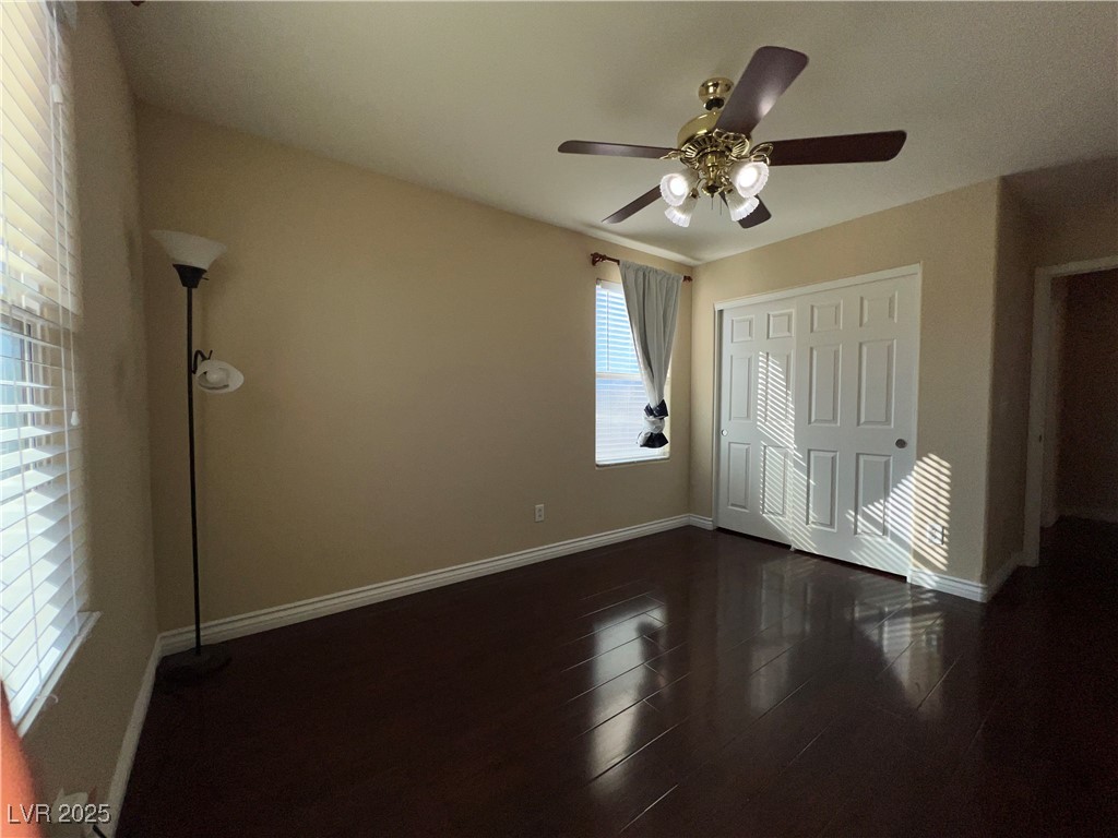 6592 Benvolio Court Las Vegas, NV 89141 - Photo 5 of 27 Unfurnished bedroom featuring dark wood-type flooring, ceiling fan, and a closet