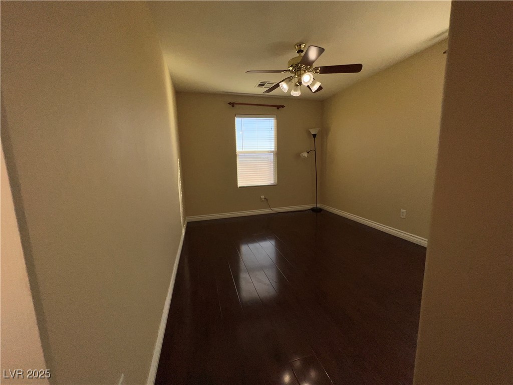 6592 Benvolio Court Las Vegas, NV 89141 - Photo 6 of 27 Unfurnished room with dark wood finished floors and ceiling fan