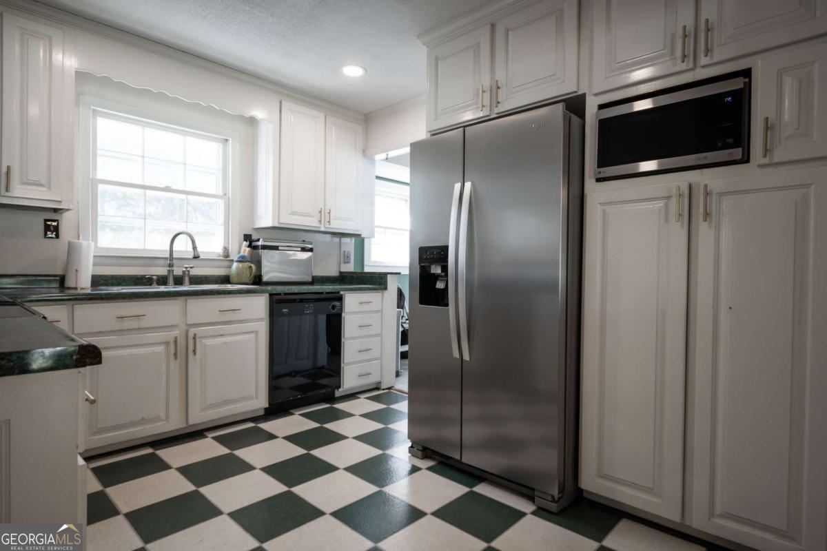 135 Tara Way Athens, GA 30606 - Photo 9 of 36 a kitchen with a sink a refrigerator and cabinets