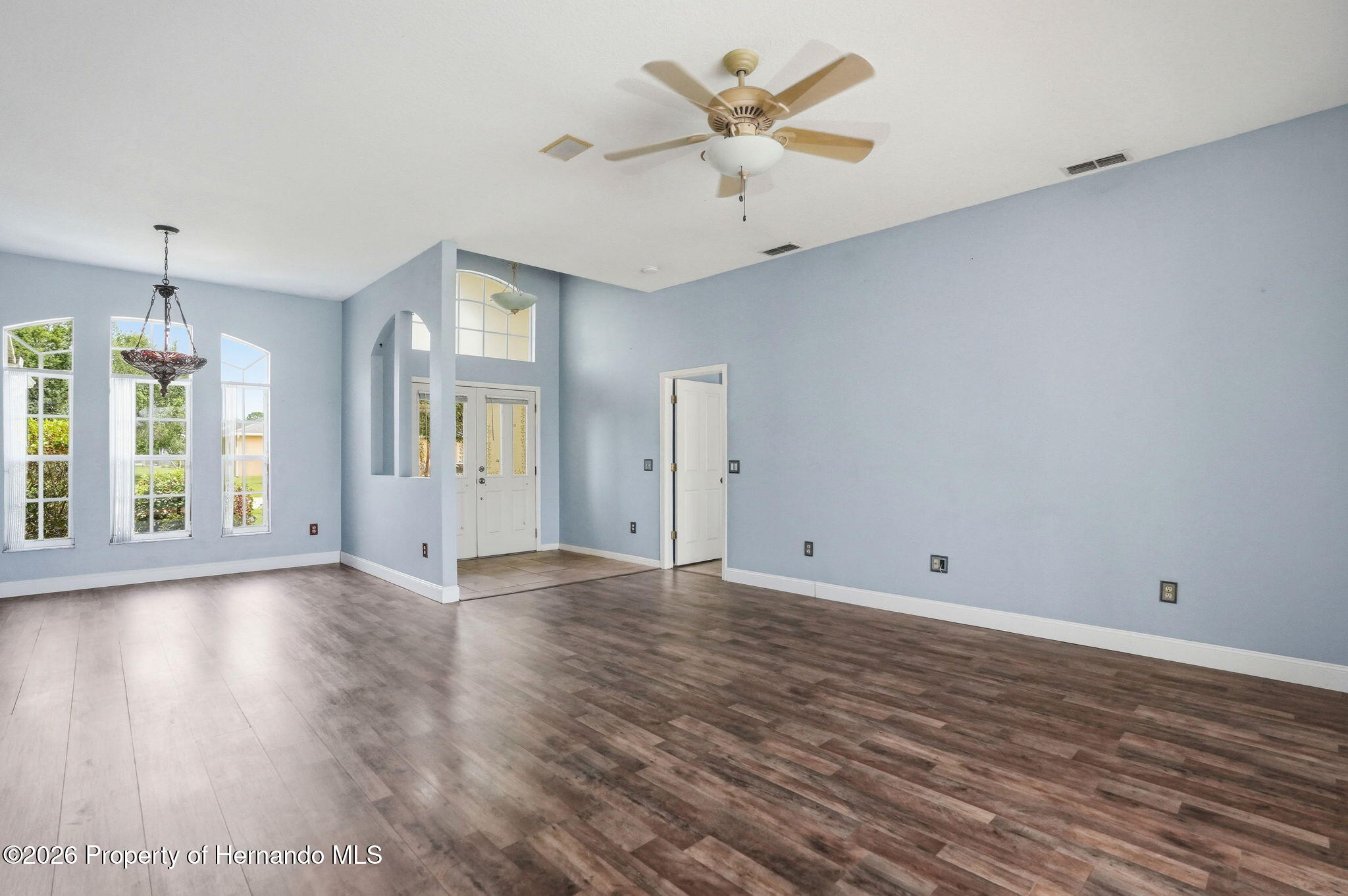 18131 Rivard Boulevard Brooksville, FL 34604 - Photo 7 of 66 wooden floor in an empty room with a window