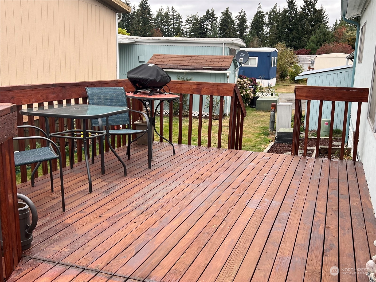 11622 Silver Lake Road, Unit 55 Everett, WA 98208 - Photo 4 of 17 a view of a roof deck with table and chairs a barbeque with wooden floor and fence