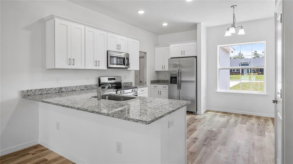 40407 West 8th Avenue Umatilla, FL 32784 - Photo 9 of 26 a kitchen with stainless steel appliances granite countertop a sink refrigerator and cabinets