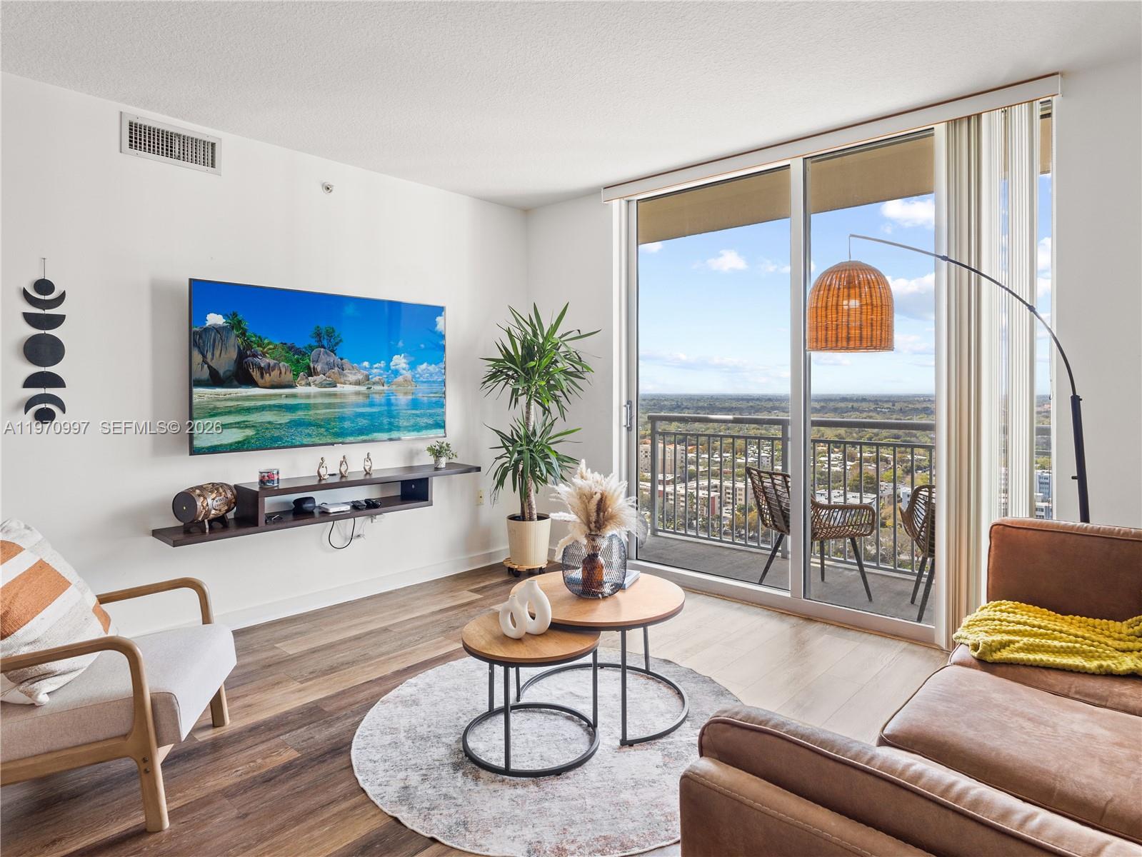 9066 Southwest 73rd Court, Unit 2008 Miami, FL 33156 - Photo 13 of 35 a living room with furniture and a flat screen tv
