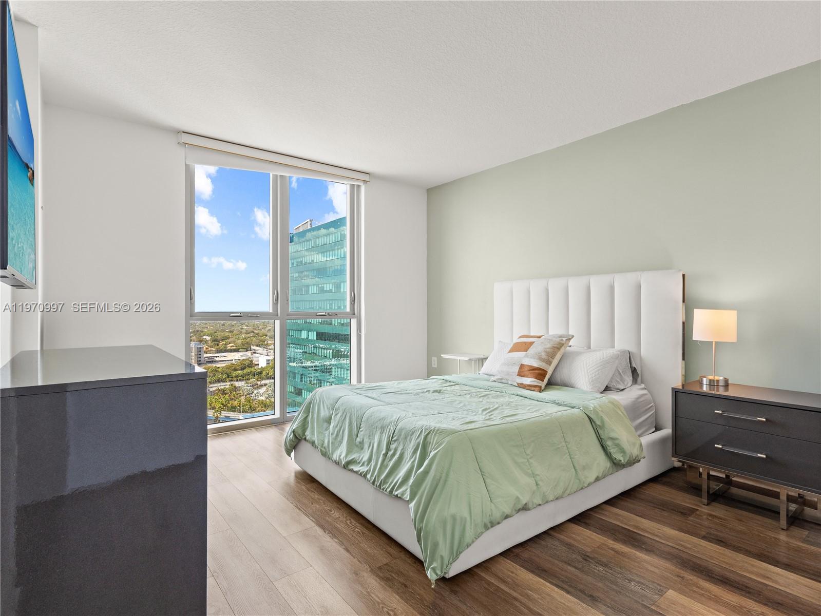 9066 Southwest 73rd Court, Unit 2008 Miami, FL 33156 - Photo 15 of 35 a bedroom with a bed and a large window