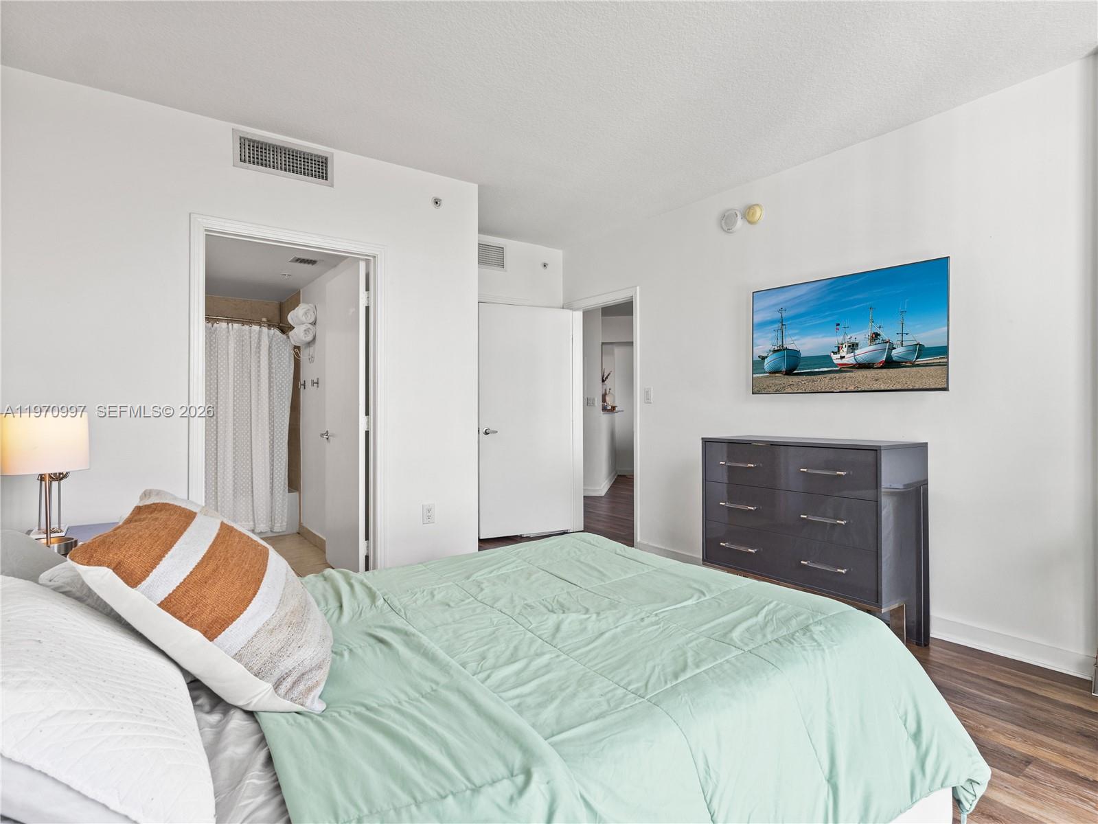 9066 Southwest 73rd Court, Unit 2008 Miami, FL 33156 - Photo 16 of 35 a bedroom with a bed and a painting on the wall