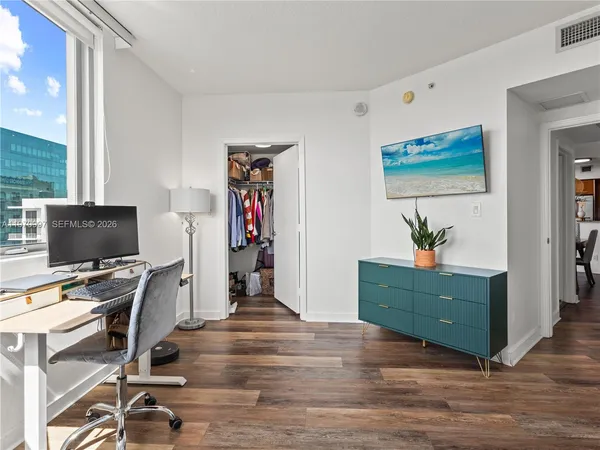 a view of a workspace with furniture and a window