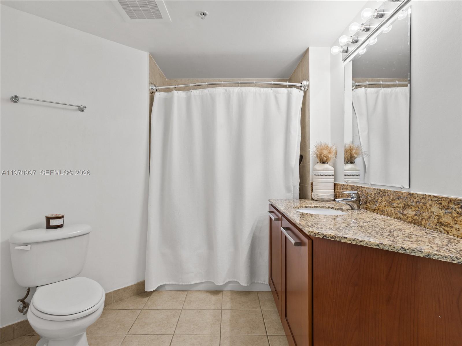 9066 Southwest 73rd Court, Unit 2008 Miami, FL 33156 - Photo 24 of 35 a bathroom with a granite countertop sink and a toilet