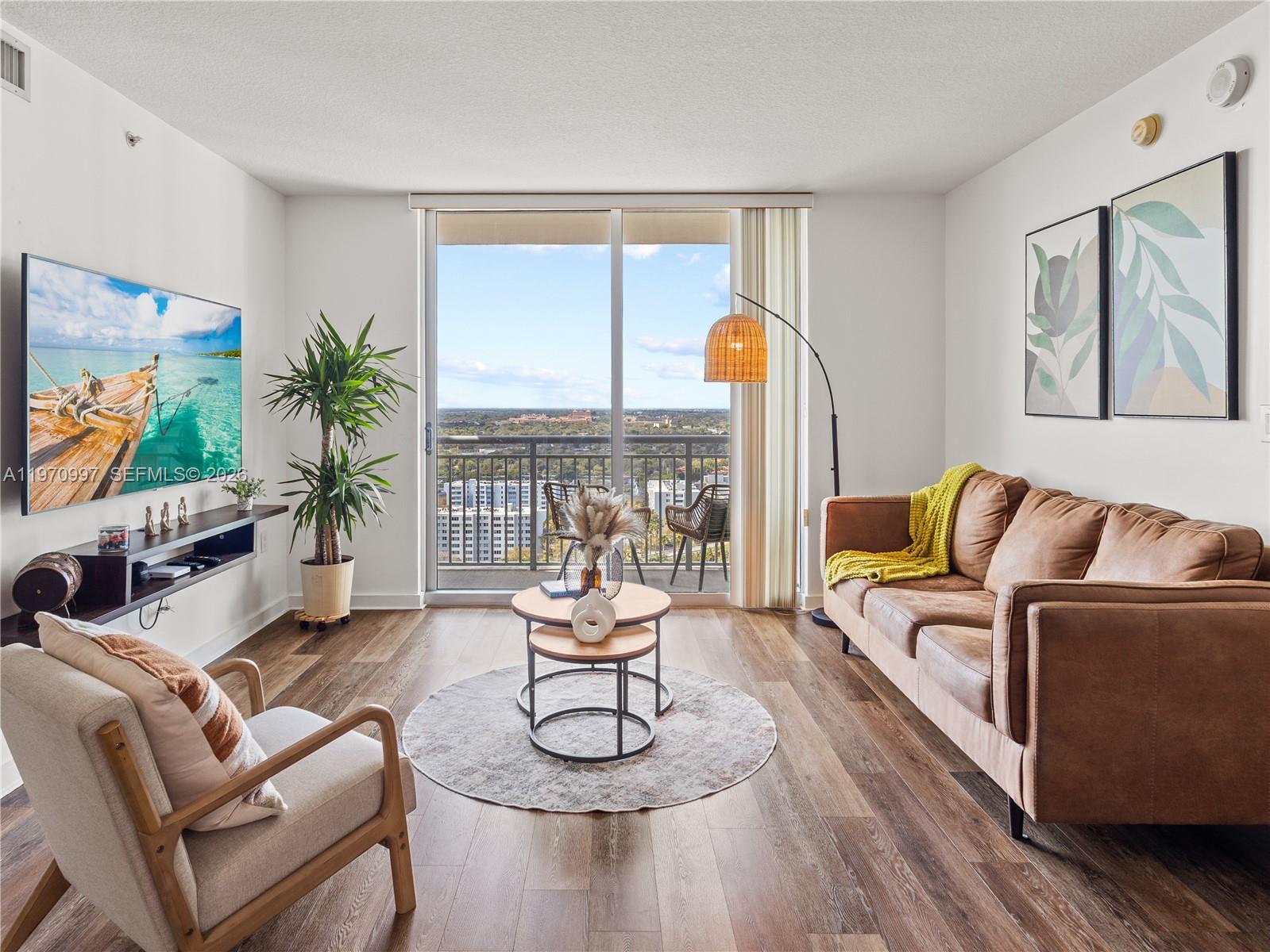 9066 Southwest 73rd Court, Unit 2008 Miami, FL 33156 - Photo 3 of 35 a living room with furniture and a flat screen tv with wooden floor