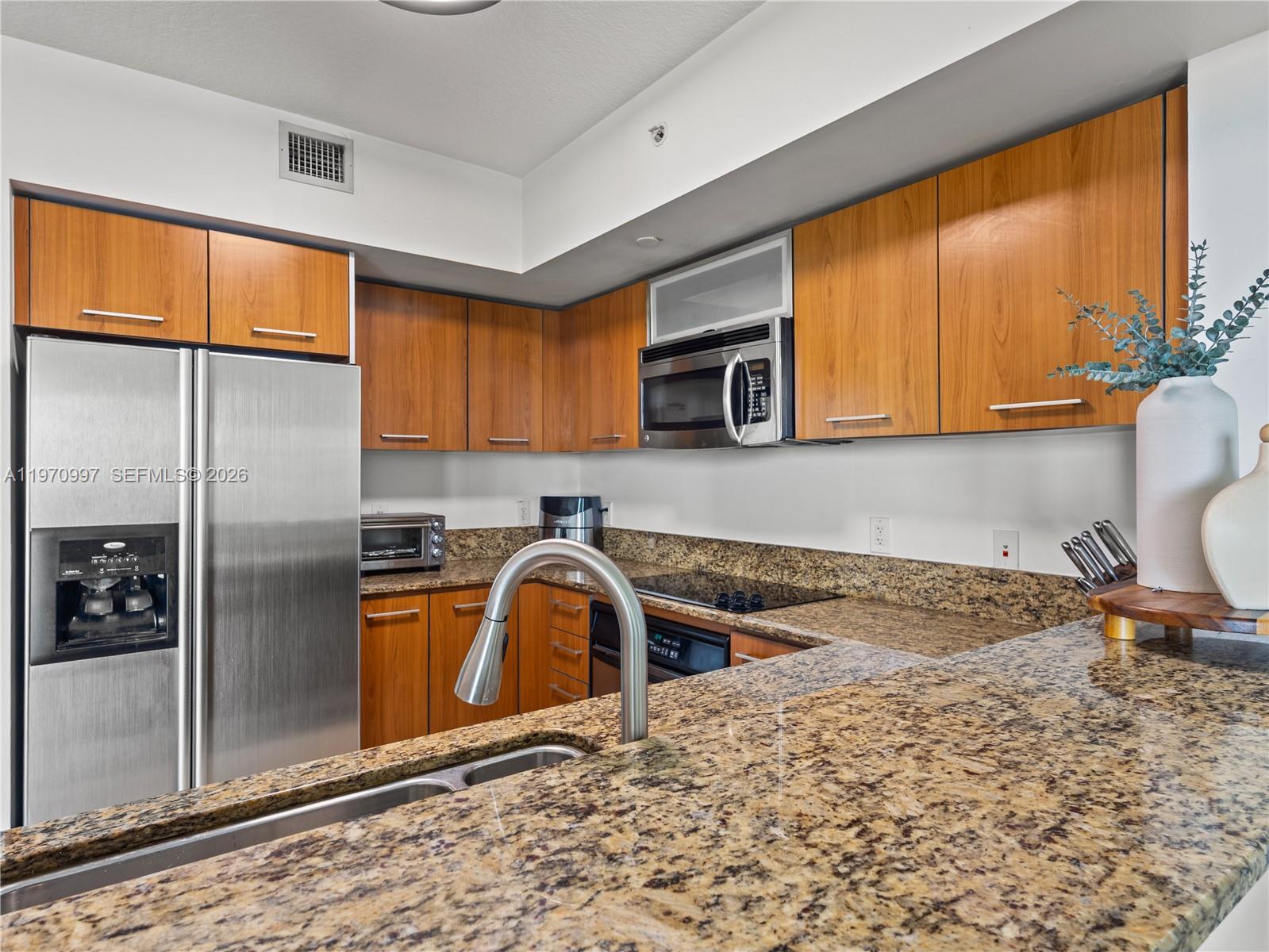 9066 Southwest 73rd Court, Unit 2008 Miami, FL 33156 - Photo 5 of 35 a kitchen with a refrigerator sink and cabinets