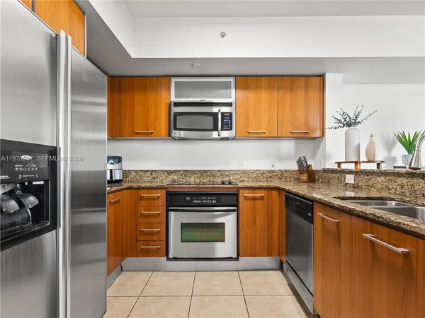 a kitchen with stainless steel appliances granite countertop a stove a sink and a microwave