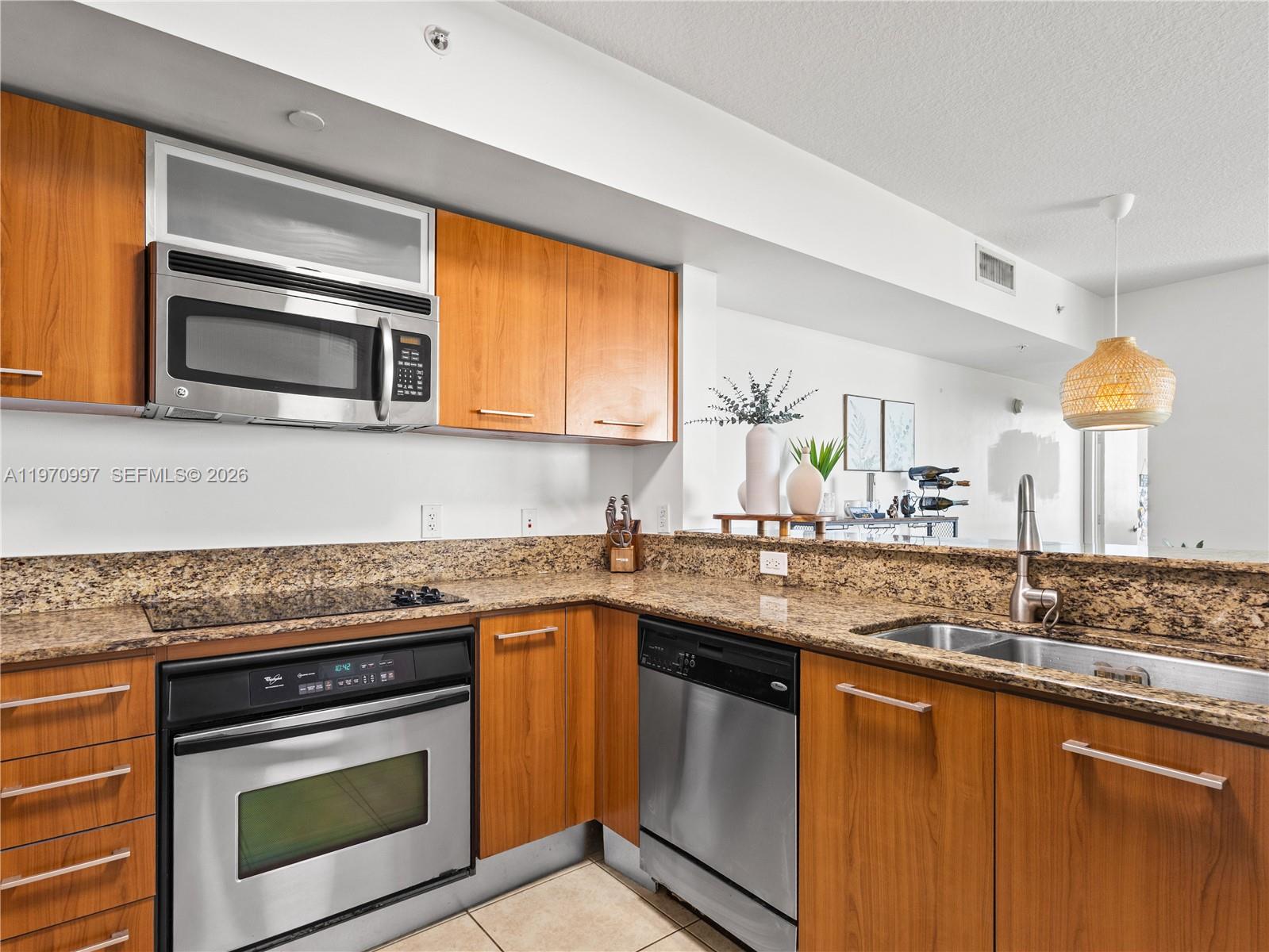 9066 Southwest 73rd Court, Unit 2008 Miami, FL 33156 - Photo 7 of 35 a kitchen with stainless steel appliances granite countertop a sink stove and microwave