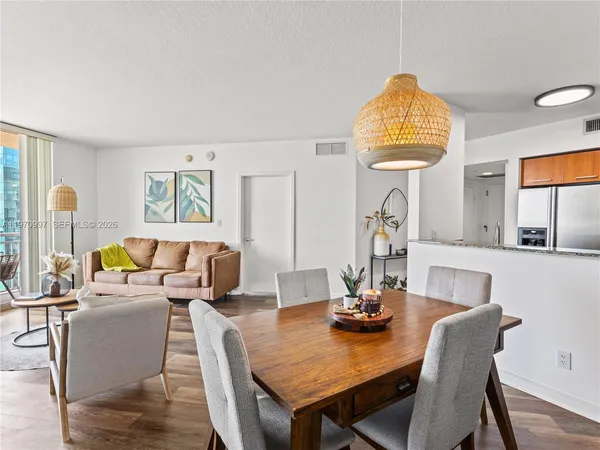 a view of a dining room with furniture a chandelier and wooden floor