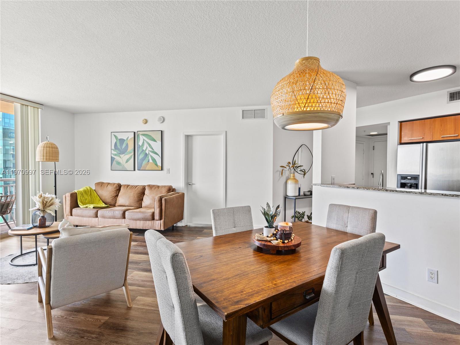 9066 Southwest 73rd Court, Unit 2008 Miami, FL 33156 - Photo 9 of 35 a view of a dining room with furniture a chandelier and wooden floor