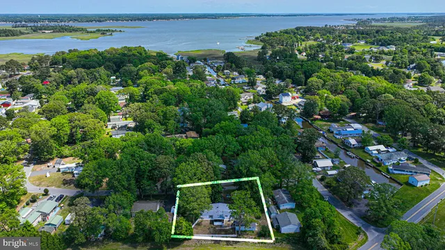 an aerial view of a city with lots of residential buildings ocean and mountain view in back