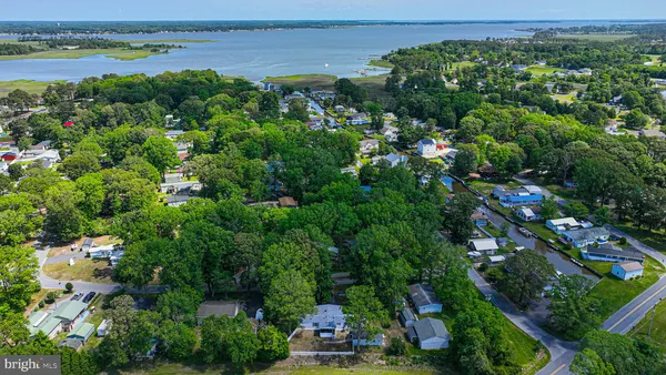 an aerial view of residential houses with outdoor space and trees
