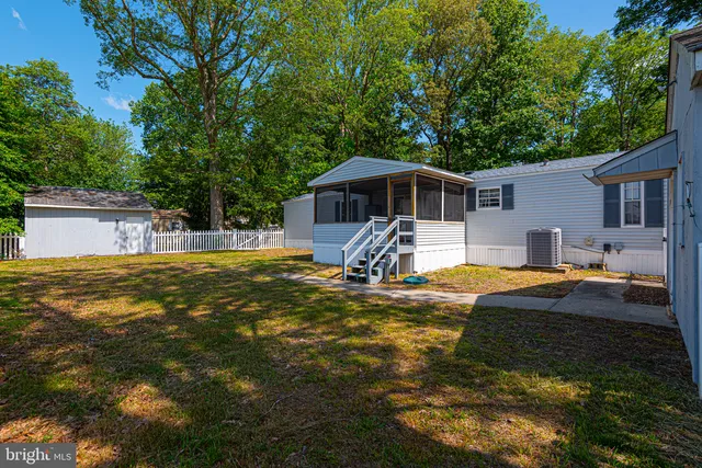 a front view of house with yard and trees in the background