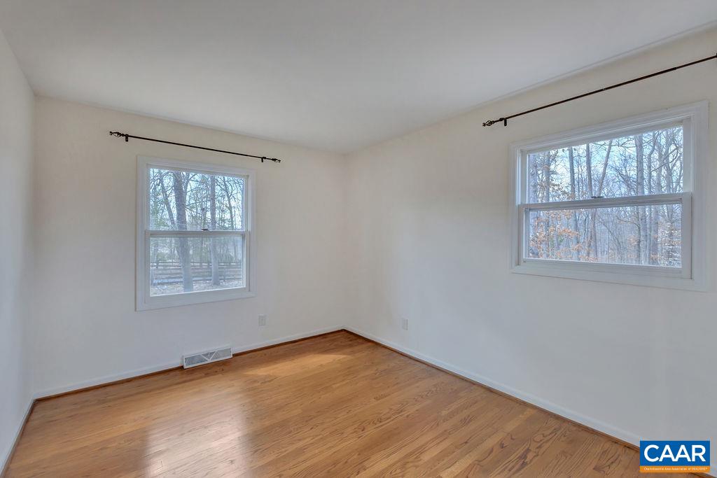385 Gillums Ridge Road Charlottesville, VA 22903 - Photo 10 of 34 a view of an empty room with wooden floor and a window