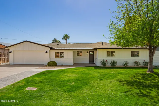a front view of a house with a yard and trees