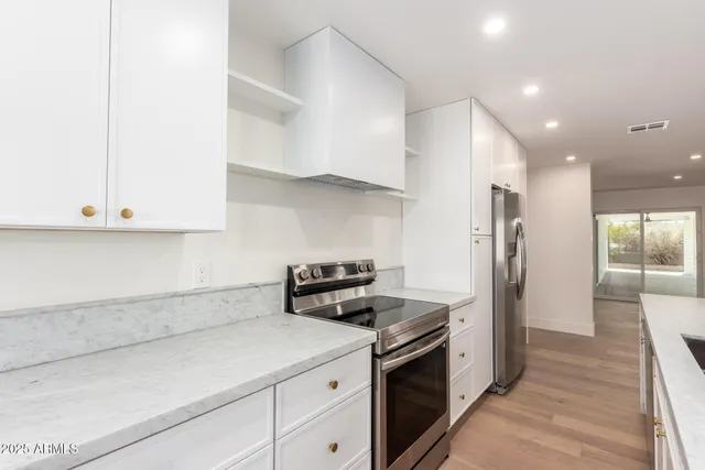 an empty room with wooden floor and a ceiling fan