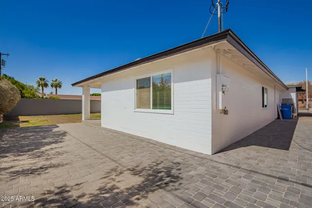 a front view of a house with a yard and large trees
