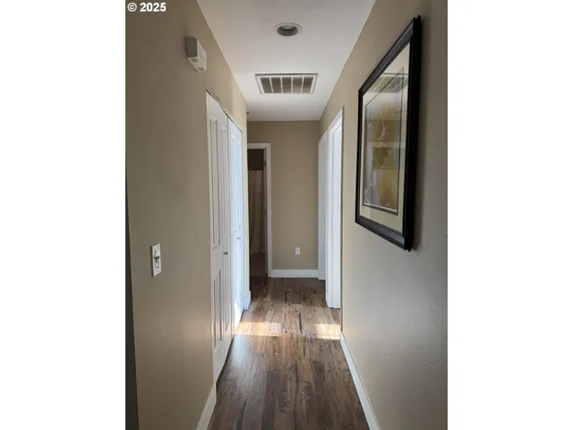 a view of a hallway with wooden floor